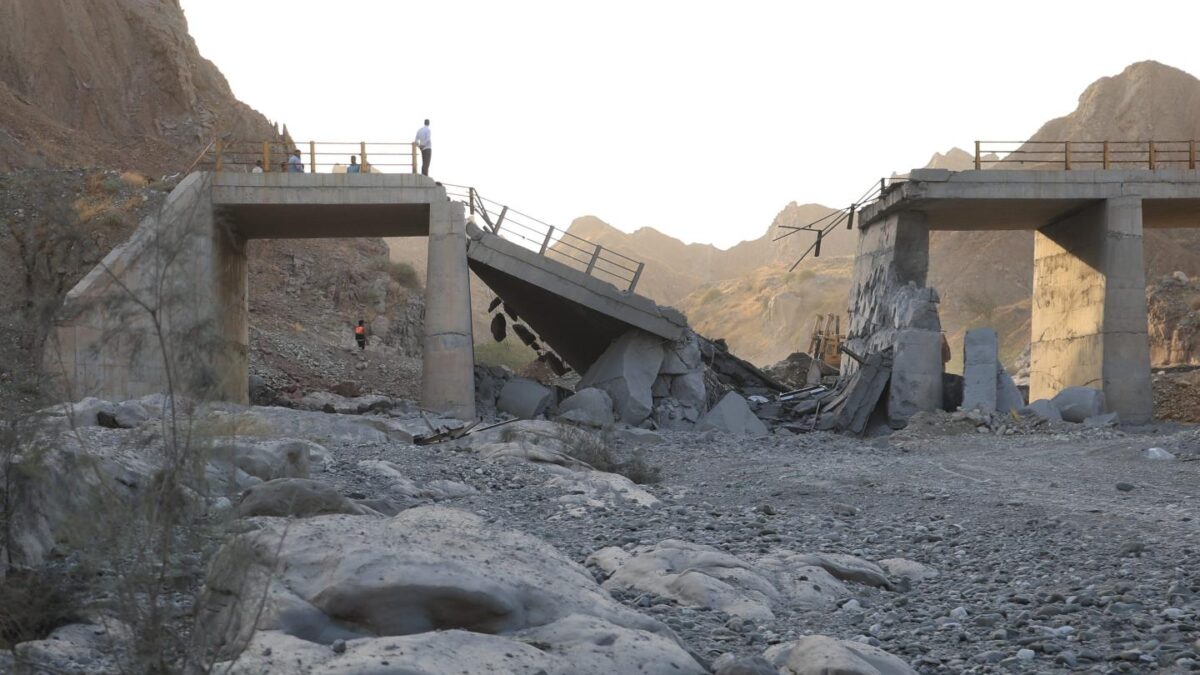 People stand on a bridge destroyed after a strike in Hormozgan province, southern Iran, Saturday, July 18, 2026.