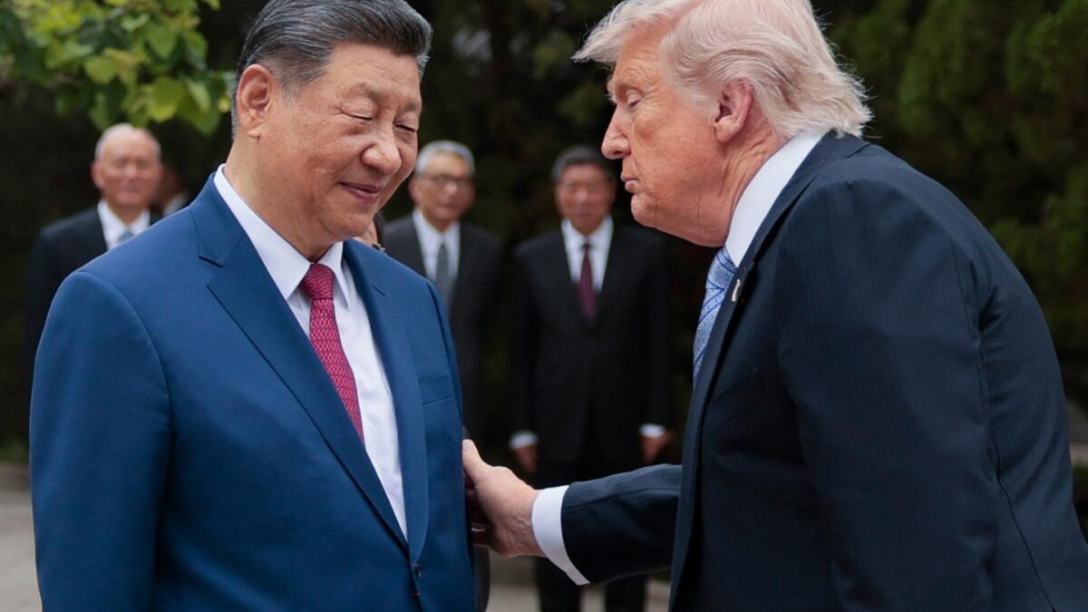 Donald Trump looks at Xi Jinping and puts a hand on his arm.