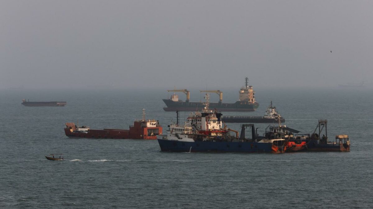 Ships sit anchored in the Strait of Hormuz as the U.S. blockade curtails Iran's oil exports.