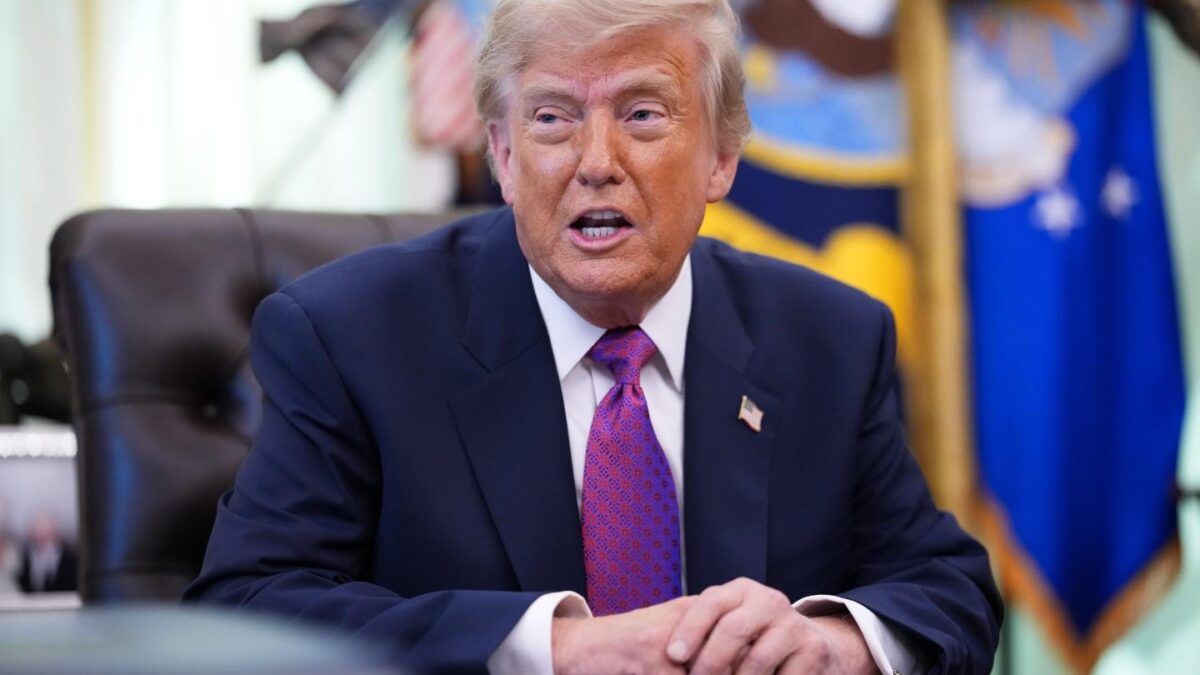 Donald Trump sits at his desk in the Oval Office.