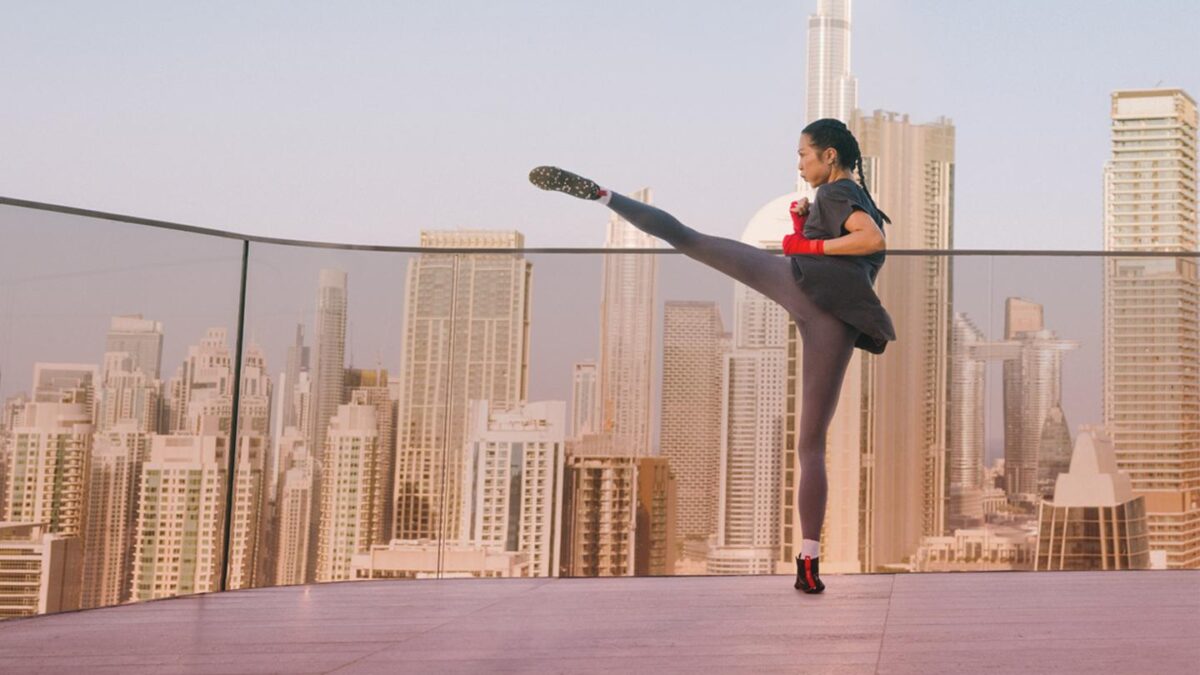A woman on a rooftop practicing kickboxing.